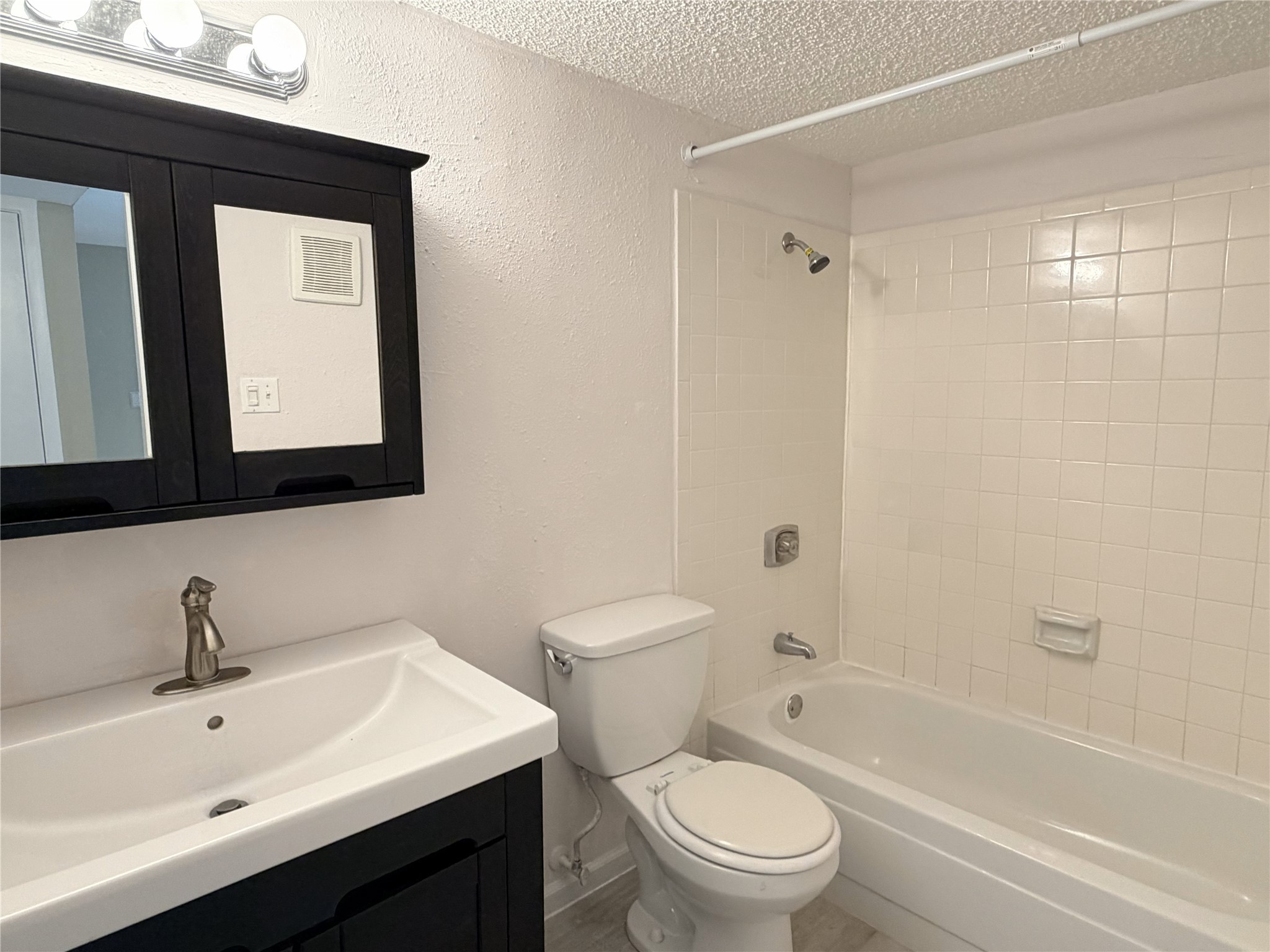 2800 Jeanetta Street, Unit 2813 Houston, TX 77063 - Photo 17 of 28 a bathroom with a toilet a sink a bath tub and a mirror