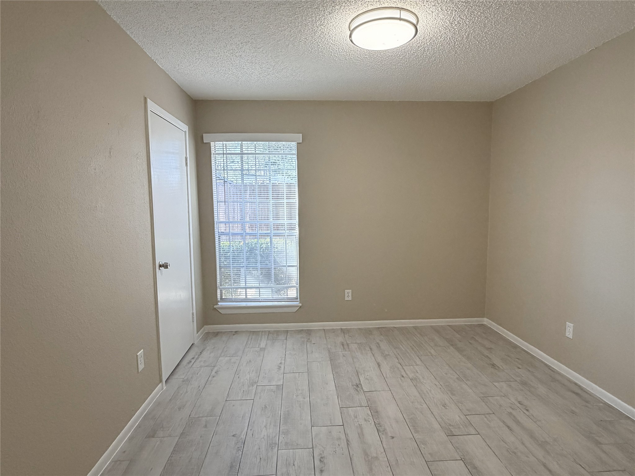 2800 Jeanetta Street, Unit 2813 Houston, TX 77063 - Photo 20 of 28 an empty room with wooden floor and windows