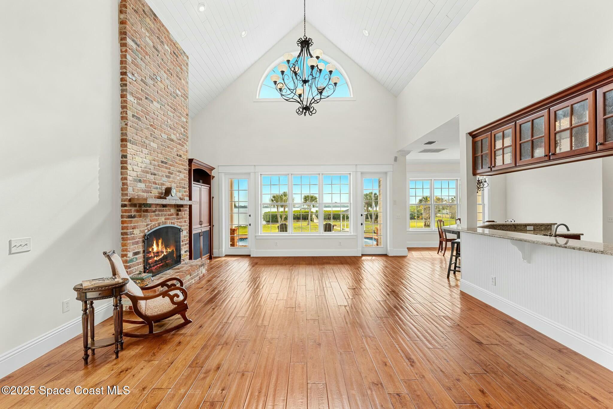 9490 South Tropical Trail Merritt Island, FL 32952 - Photo 11 of 63 a view of a livingroom with furniture a fireplace wooden floor and windows