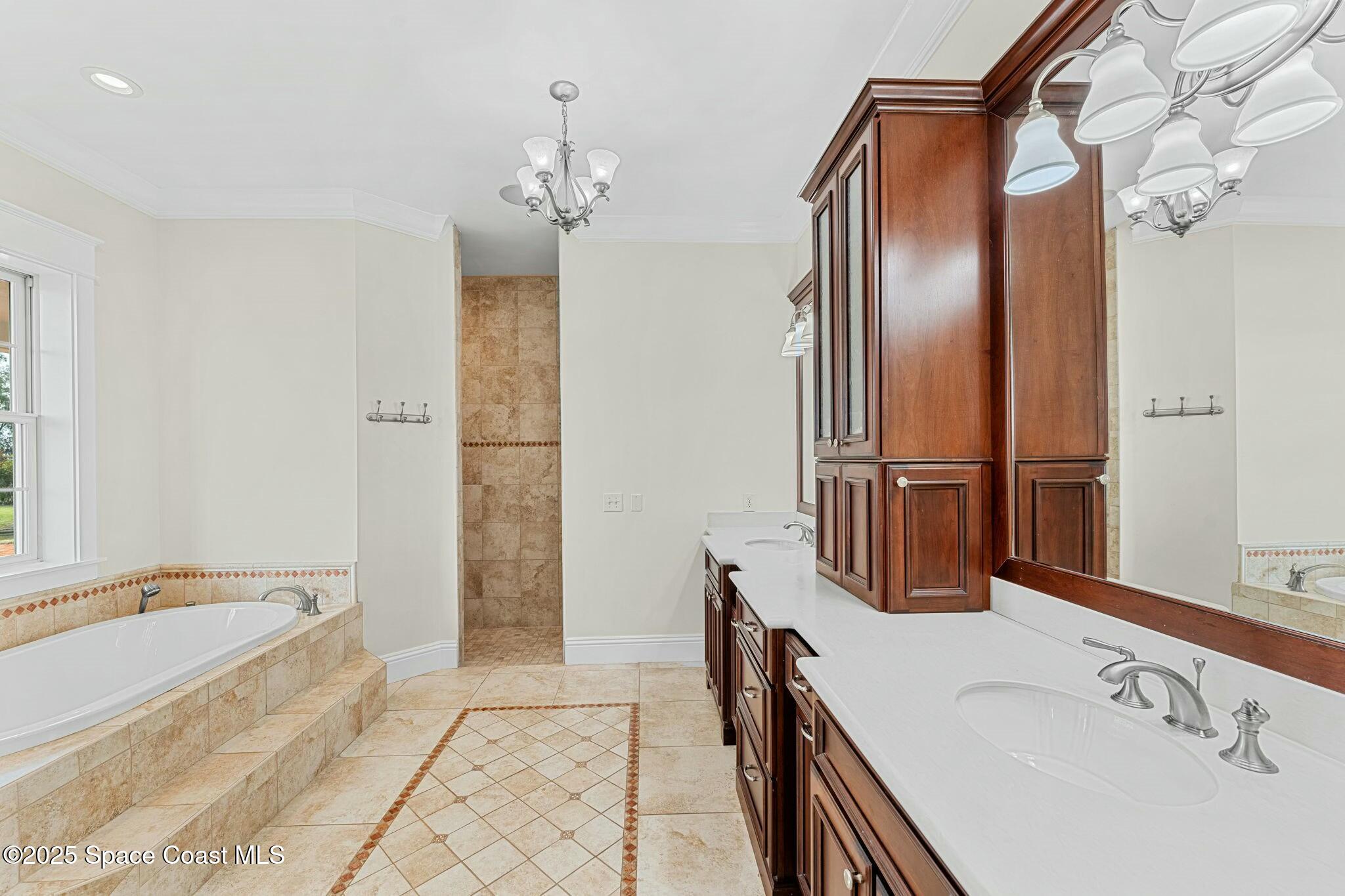 9490 South Tropical Trail Merritt Island, FL 32952 - Photo 30 of 63 a bathroom with a tub sink and mirror