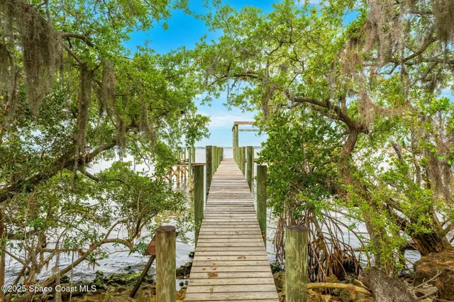 a view of a patio with table and chairs near a barbeque