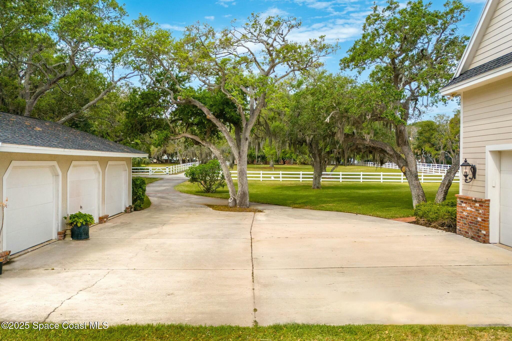 9490 South Tropical Trail Merritt Island, FL 32952 - Photo 58 of 63 a view of a house with a backyard and a garage