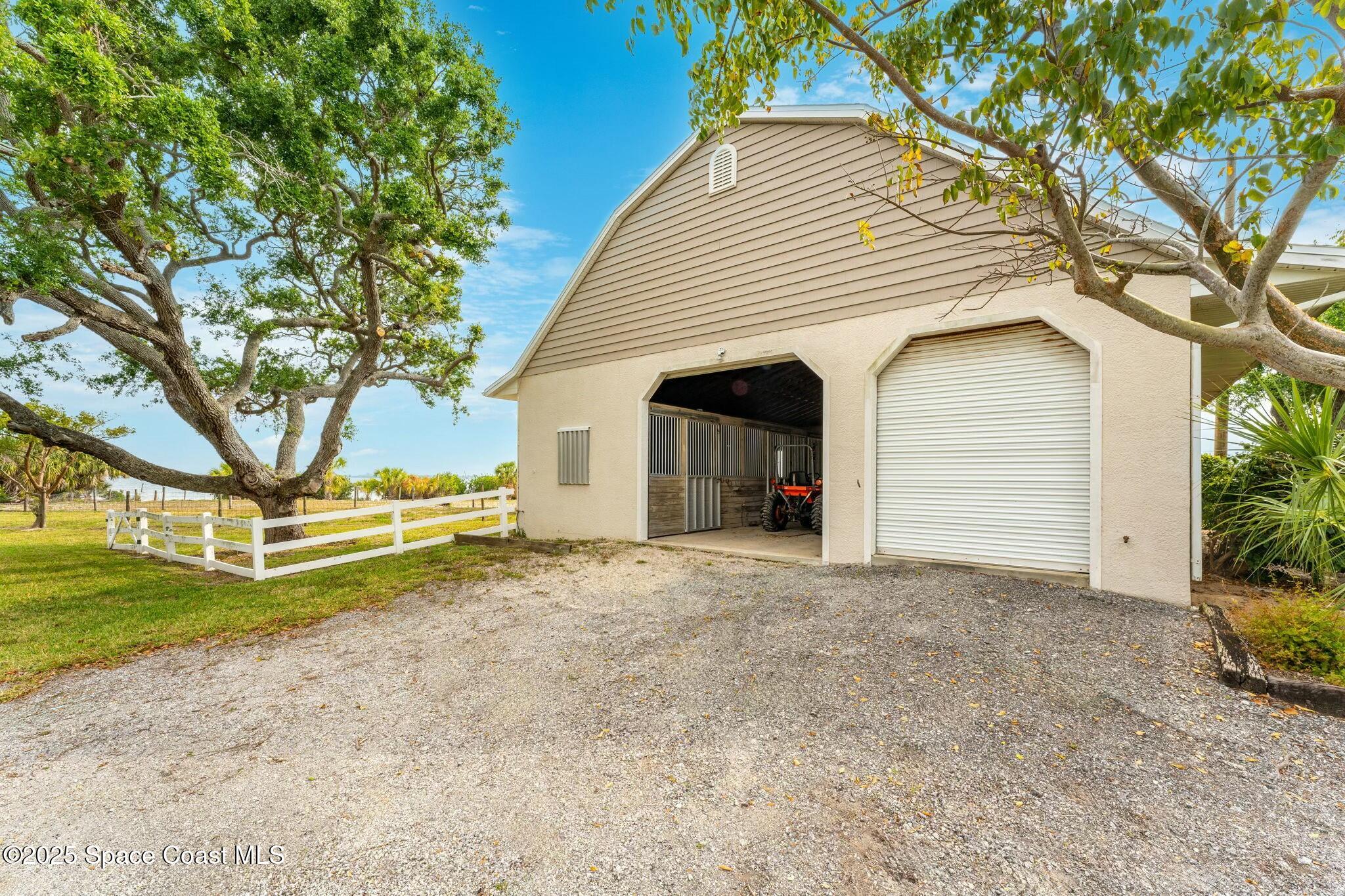 9490 South Tropical Trail Merritt Island, FL 32952 - Photo 61 of 63 a view of a house with a yard and garage