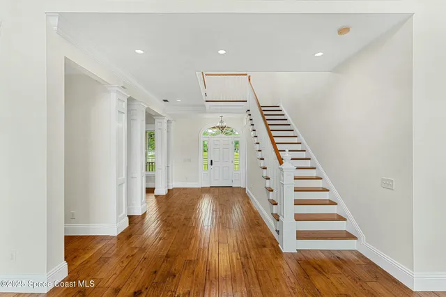 a view of an empty room with wooden floor fireplace and a window