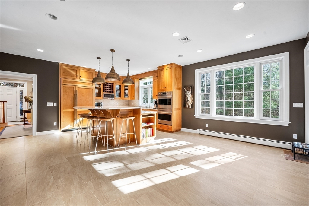 98 Valley Road Boxford, MA 01921 - Photo 13 of 40 a view of a kitchen with stainless steel appliances kitchen island granite countertop a refrigerator a stove a dining table and chairs with wooden floor