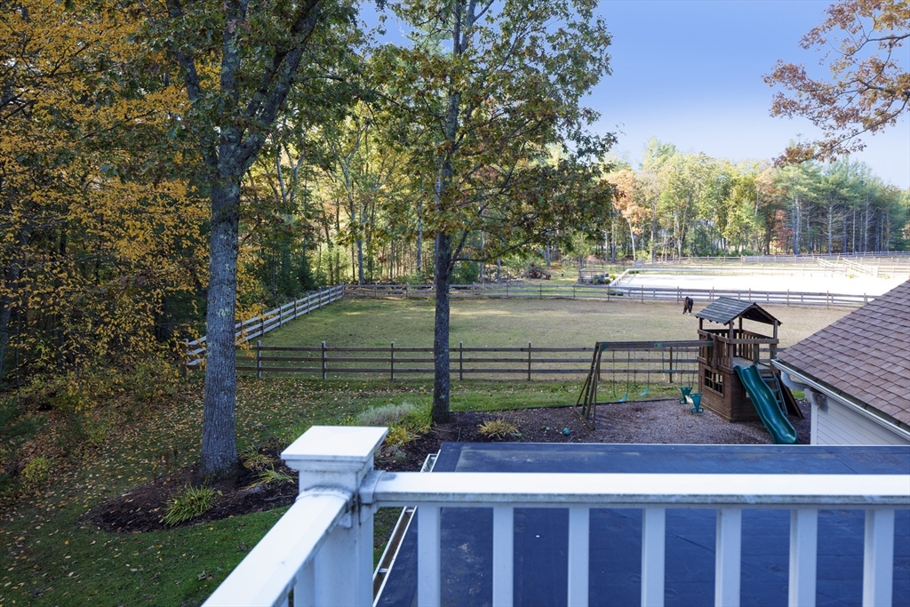 98 Valley Road Boxford, MA 01921 - Photo 17 of 40 a view of a deck with a table and chairs a fire pit and a large tree
