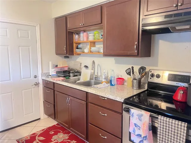 a kitchen with granite countertop a sink stove and cabinets
