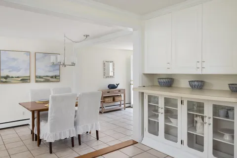 a kitchen with a white cabinets and chairs