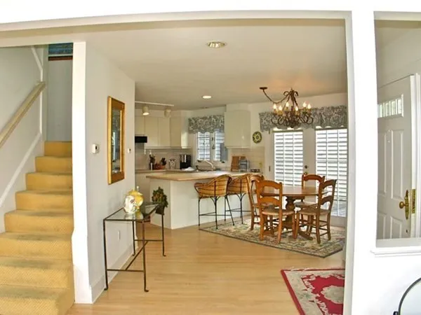 a living room with dining table and a large window with garden view