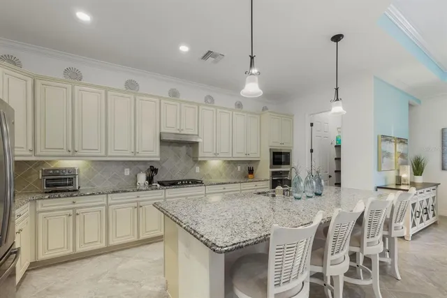 a kitchen with stainless steel appliances granite countertop a sink stove and refrigerator