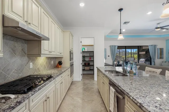 a living room with furniture kitchen view and a chandelier