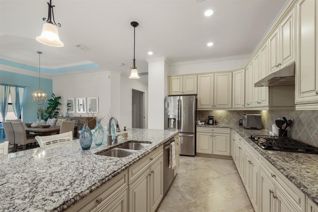 6036 Cessna Run Bradenton, FL 34211 - Photo 14 of 75 a kitchen with stainless steel appliances granite countertop a sink stove and refrigerator