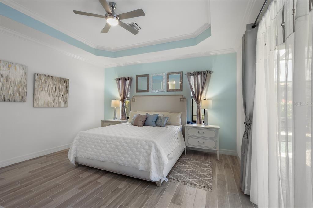 6036 Cessna Run Bradenton, FL 34211 - Photo 18 of 75 a bedroom with a bed wooden floor and a ceiling fan