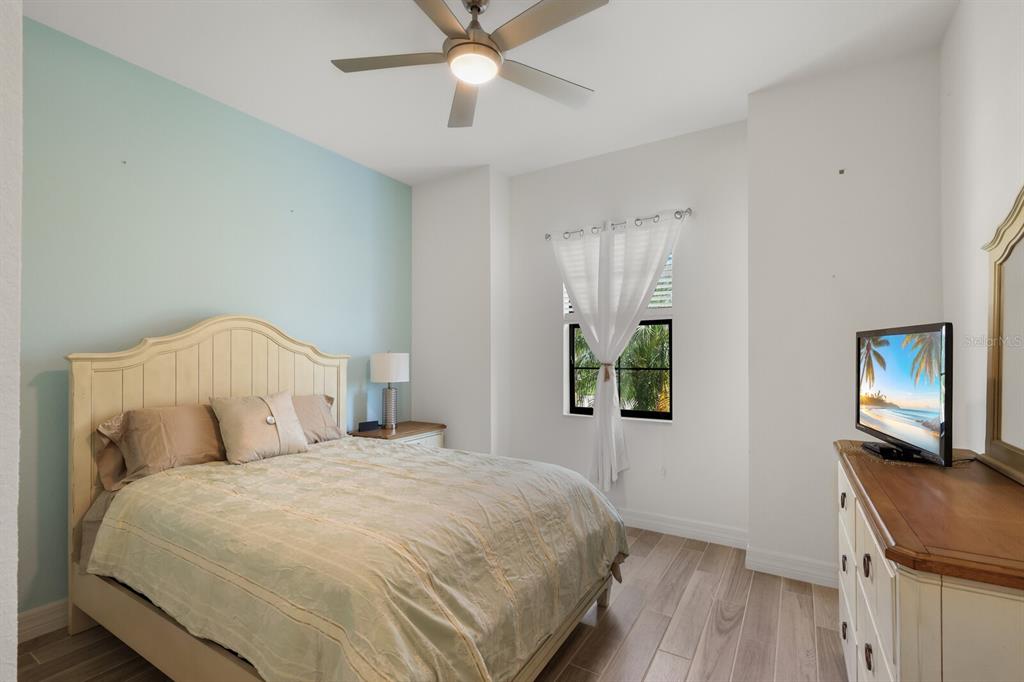 6036 Cessna Run Bradenton, FL 34211 - Photo 24 of 75 a bedroom with a bed and a flat tv screen on dresser