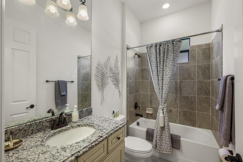 6036 Cessna Run Bradenton, FL 34211 - Photo 26 of 75 a bathroom with a granite countertop sink toilet mirror and shower