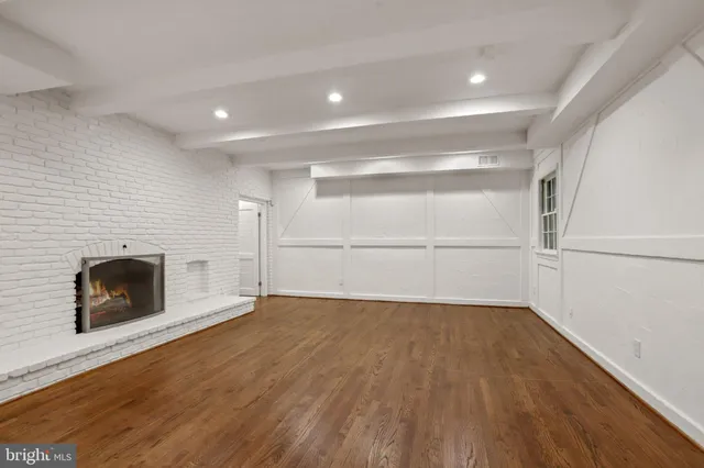 a view of a room with wooden floors and kitchen