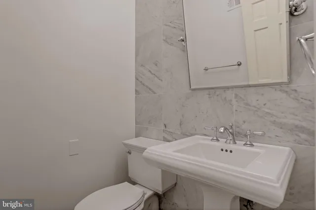 a bathroom with a sink a toilet and mirror
