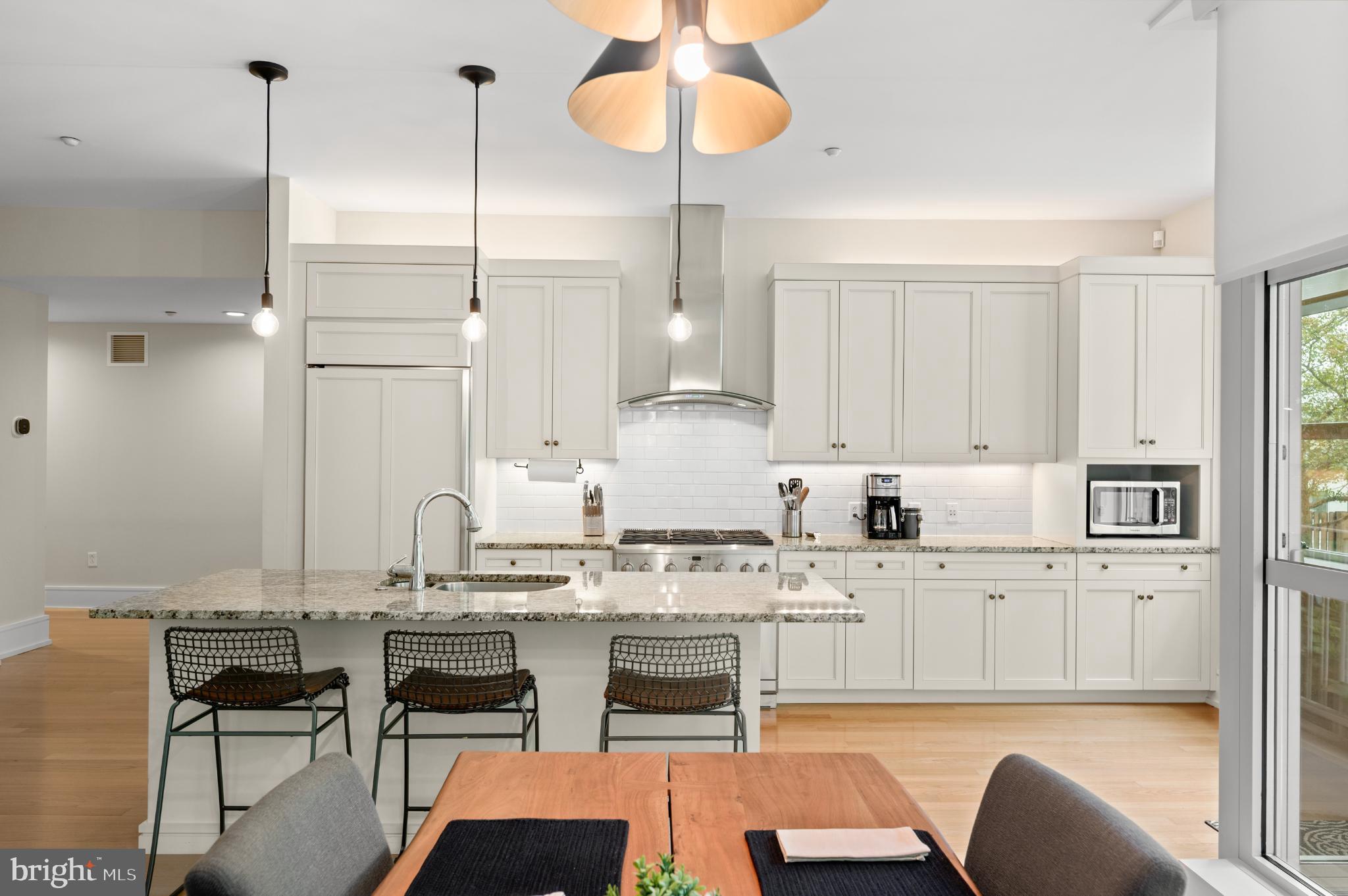 112 Iron Works Way Wayne, PA 19087 - Photo 15 of 50 a kitchen with stainless steel appliances kitchen island granite countertop a stove a sink a refrigerator and white cabinets with wooden floor