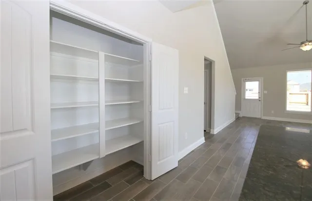 a view of a room with wooden floor and windows