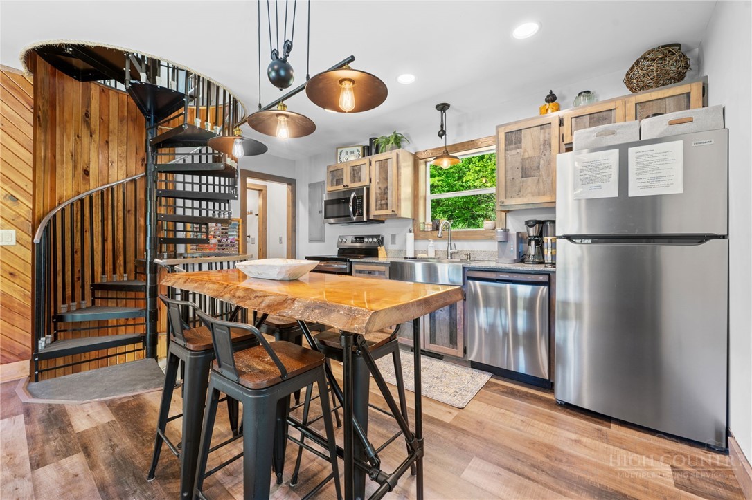 634-636 Watauga River Road Sugar Grove, NC 28679 - Photo 22 of 50 a kitchen with stainless steel appliances granite countertop a stove a refrigerator a dining table and chairs with wooden floor