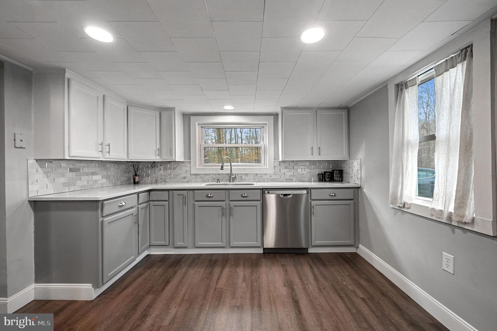 a kitchen with a sink wooden floor and window