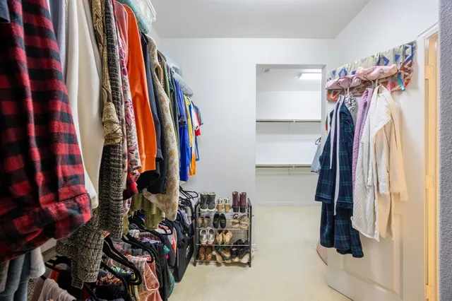 a view of walk in closet with clothes