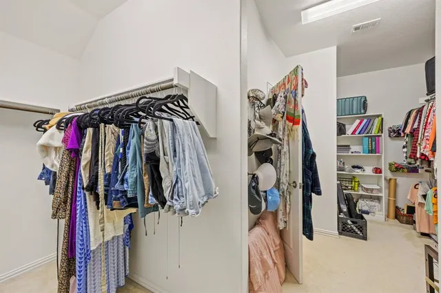 a view of walk in closet with clothes and shoes