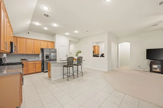 a kitchen with stainless steel appliances kitchen island granite countertop a sink and cabinets