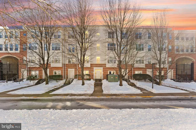 a view of white house with a yard covered with snow