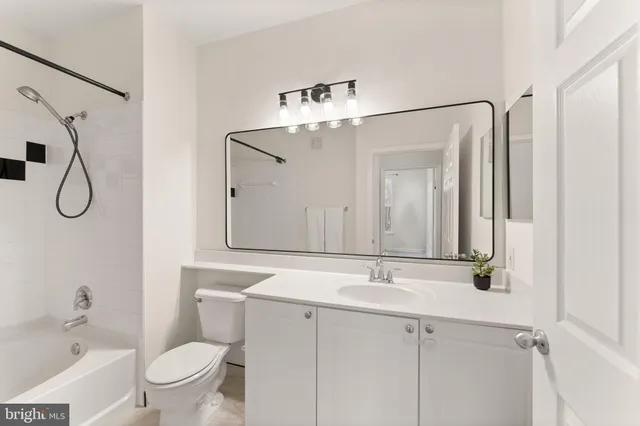 a bathroom with a granite countertop sink a toilet and a mirror