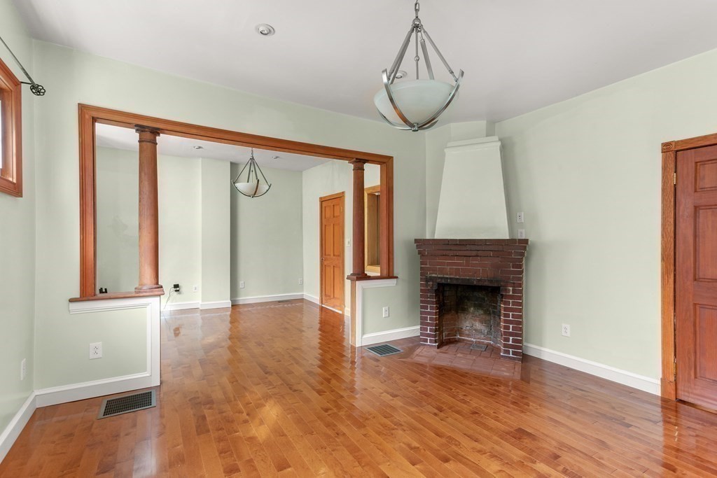 28 Stebbins Street Worcester, MA 01607 - Photo 10 of 29 a view of an empty room with wooden floor fireplace and a window