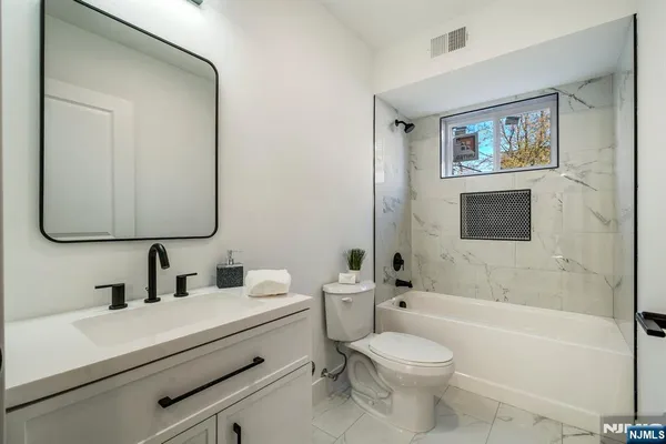 a bathroom with a toilet sink shower and mirror