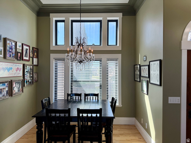 202 375 West Providence, UT 84332 - Photo 8 of 61 Dining room featuring plenty of natural light through beautiful windows, ornamental molding, light wood finished floors, and a chandelier