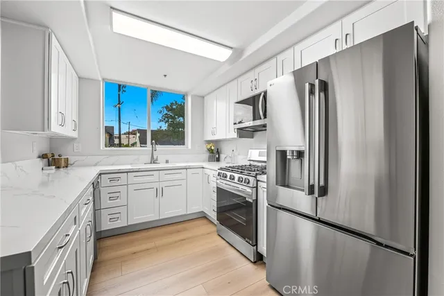 a kitchen with stainless steel appliances a refrigerator sink and microwave