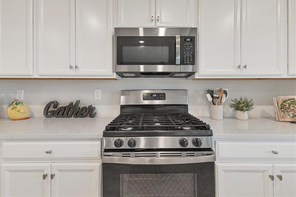 18113 Gawthrop Drive, Unit 101 Lakewood Ranch, FL 34211 - Photo 15 of 73 a kitchen with stainless steel appliances granite countertop a stove a microwave and cabinets