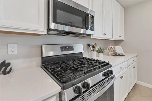 a dining room with wooden floor a chandelier a glass table and chairs
