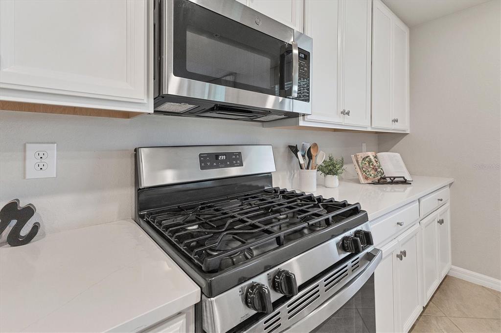 18113 Gawthrop Drive, Unit 101 Lakewood Ranch, FL 34211 - Photo 16 of 73 a kitchen with stainless steel appliances granite countertop white cabinets and stove
