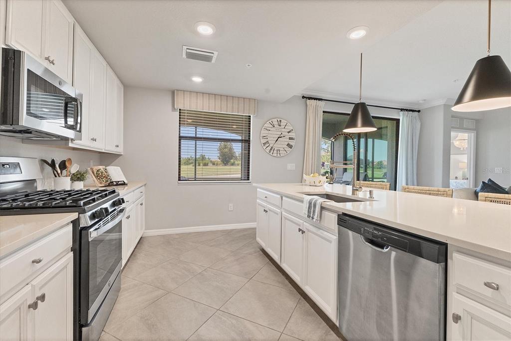 18113 Gawthrop Drive, Unit 101 Lakewood Ranch, FL 34211 - Photo 17 of 73 a kitchen with stainless steel appliances granite countertop a sink and stove top oven