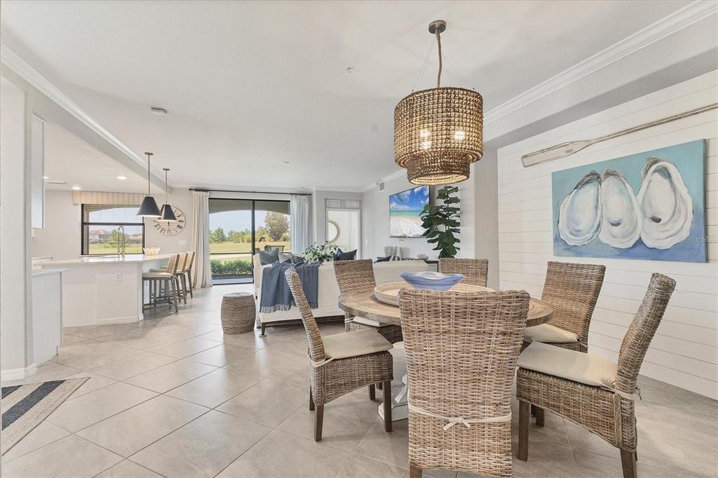 18113 Gawthrop Drive, Unit 101 Lakewood Ranch, FL 34211 - Photo 19 of 73 a dining room with wooden floor a chandelier a glass table and chairs