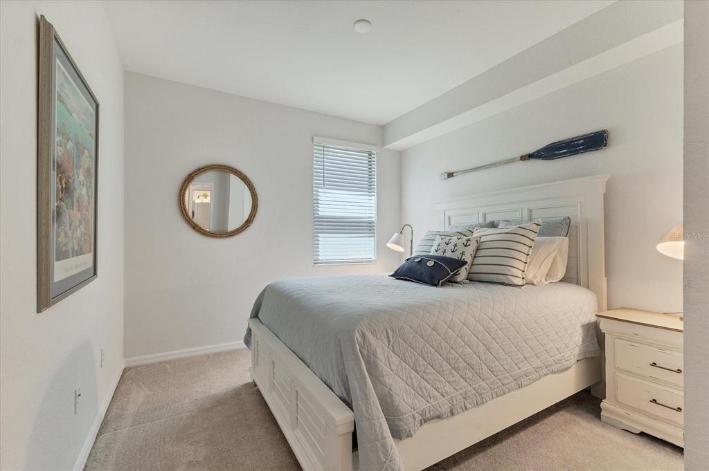 18113 Gawthrop Drive, Unit 101 Lakewood Ranch, FL 34211 - Photo 24 of 73 a bedroom with a bed and a chandelier