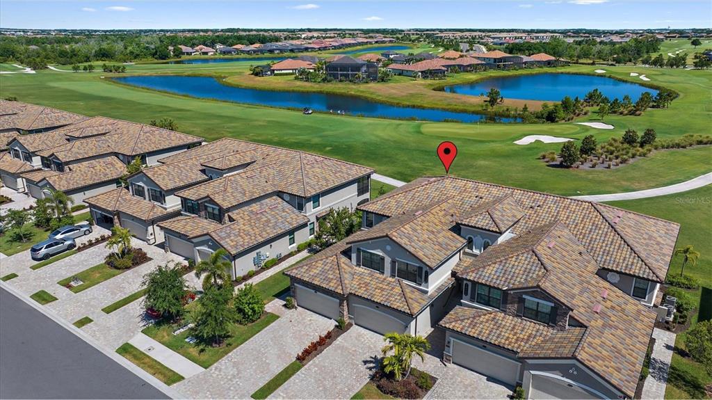 18113 Gawthrop Drive, Unit 101 Lakewood Ranch, FL 34211 - Photo 5 of 73 an aerial view of a house with a garden and lake view