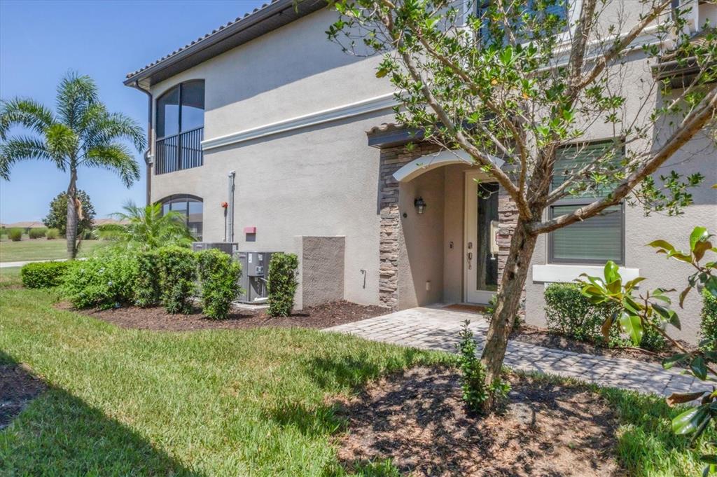 18113 Gawthrop Drive, Unit 101 Lakewood Ranch, FL 34211 - Photo 6 of 73 a front view of a house with garden