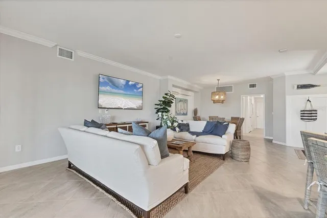 a living room with furniture kitchen view and a potted plant