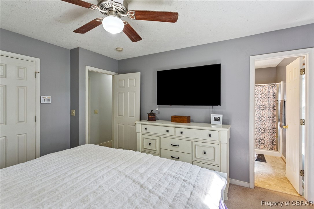 7989 Pinetta Road Gloucester, VA 23061 - Photo 16 of 26 Bedroom featuring light carpet, a ceiling fan, and ensuite bath