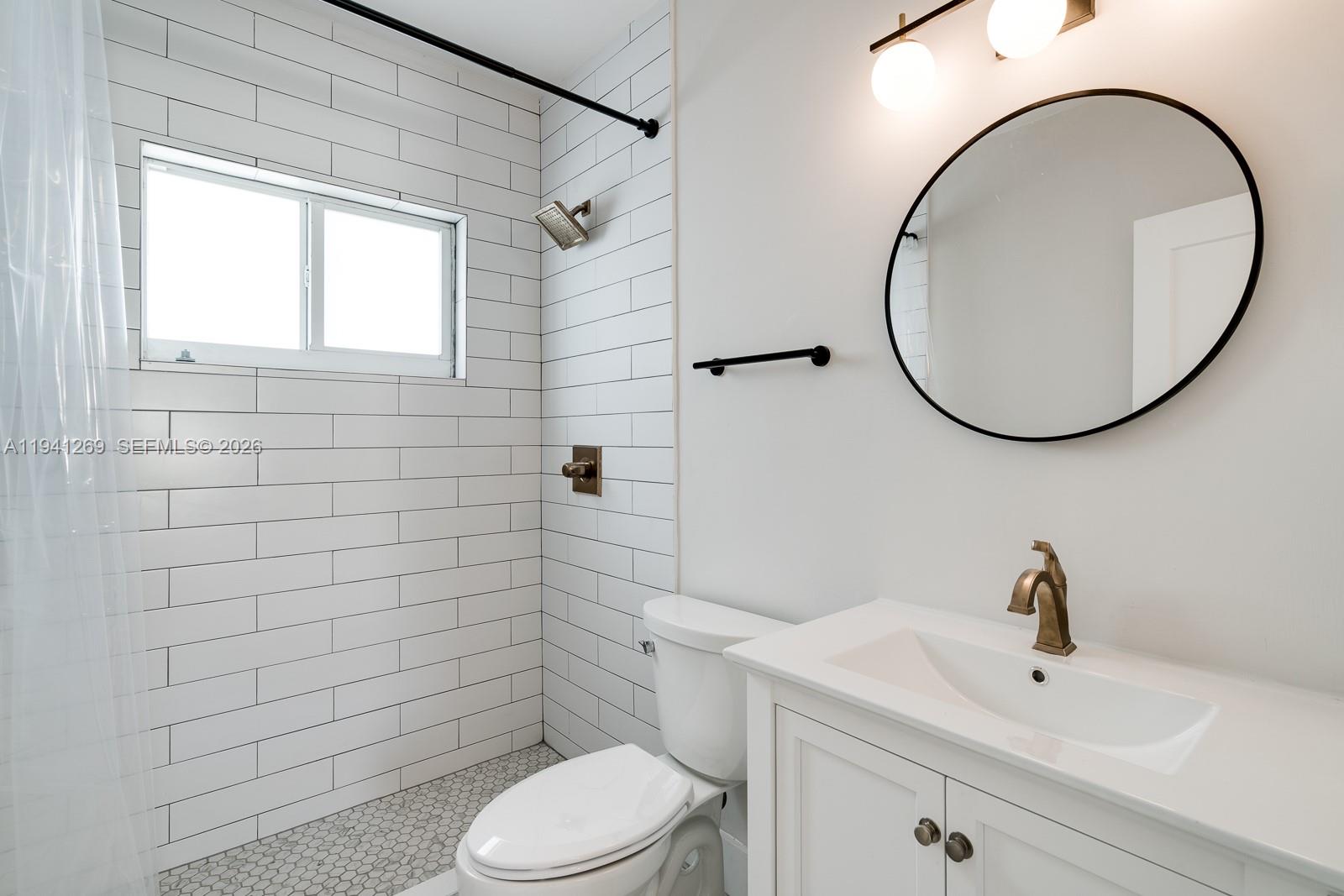 2922 South Le Jeune Road, Unit 2 Coral Gables, FL 33134 - Photo 12 of 17 a bathroom with a sink a toilet and a mirror