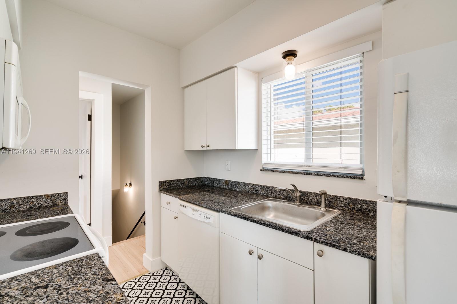 2922 South Le Jeune Road, Unit 2 Coral Gables, FL 33134 - Photo 6 of 16 a kitchen with a sink stove and cabinets