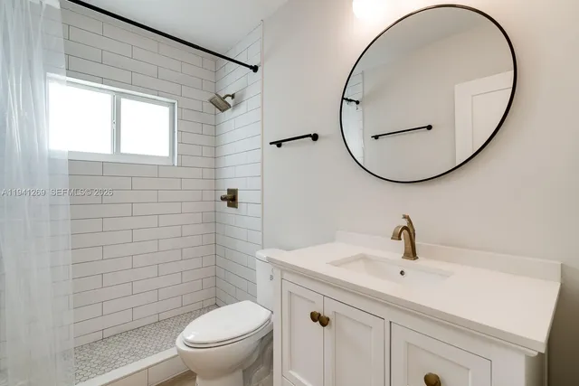 a bathroom with a toilet a sink and a mirror
