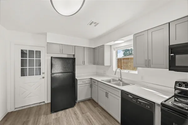 a kitchen with a sink a refrigerator and cabinets