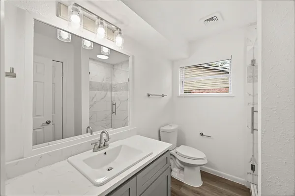 a bathroom with a sink toilet and shower