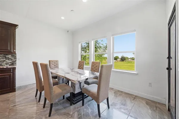 a view of kitchen with dining area refrigerator and wooden floor